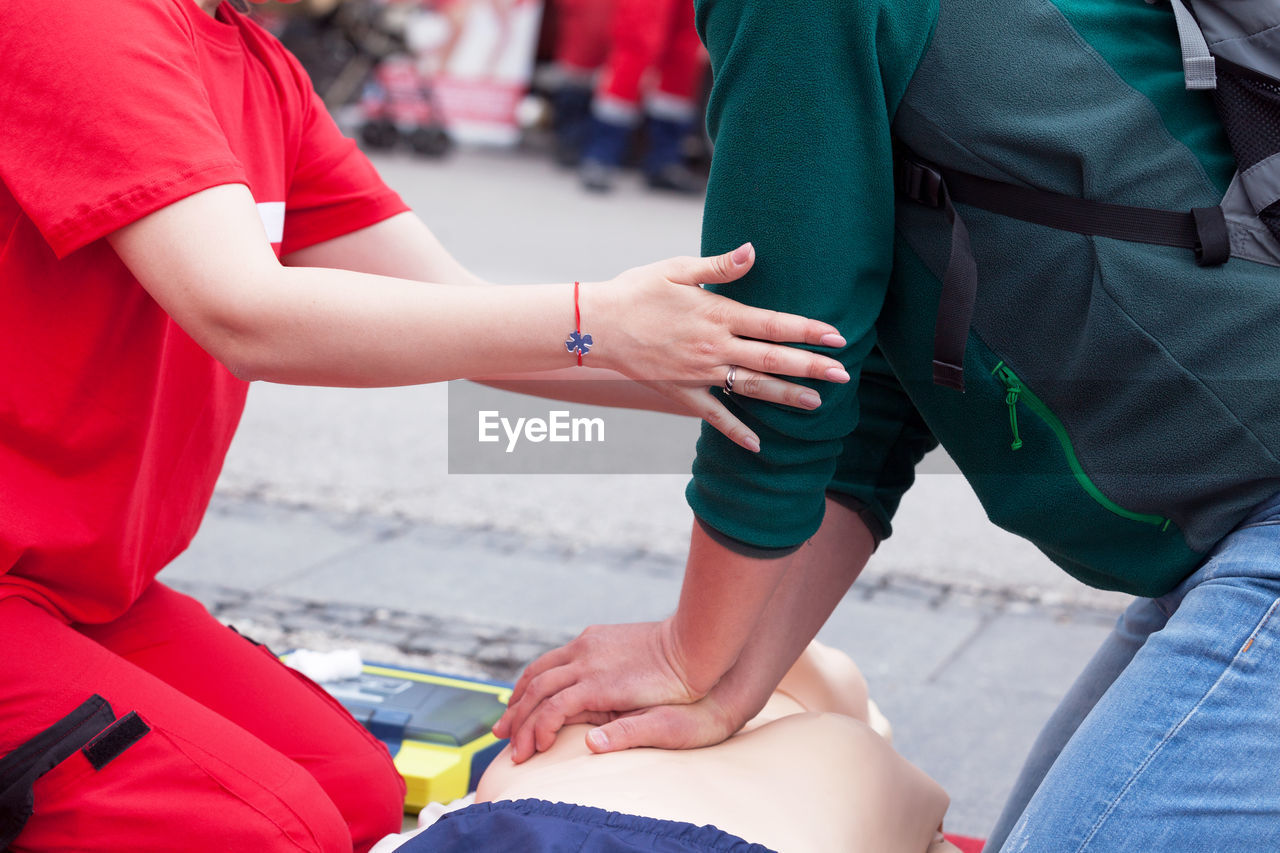 Midsection of women giving cpr on dummy