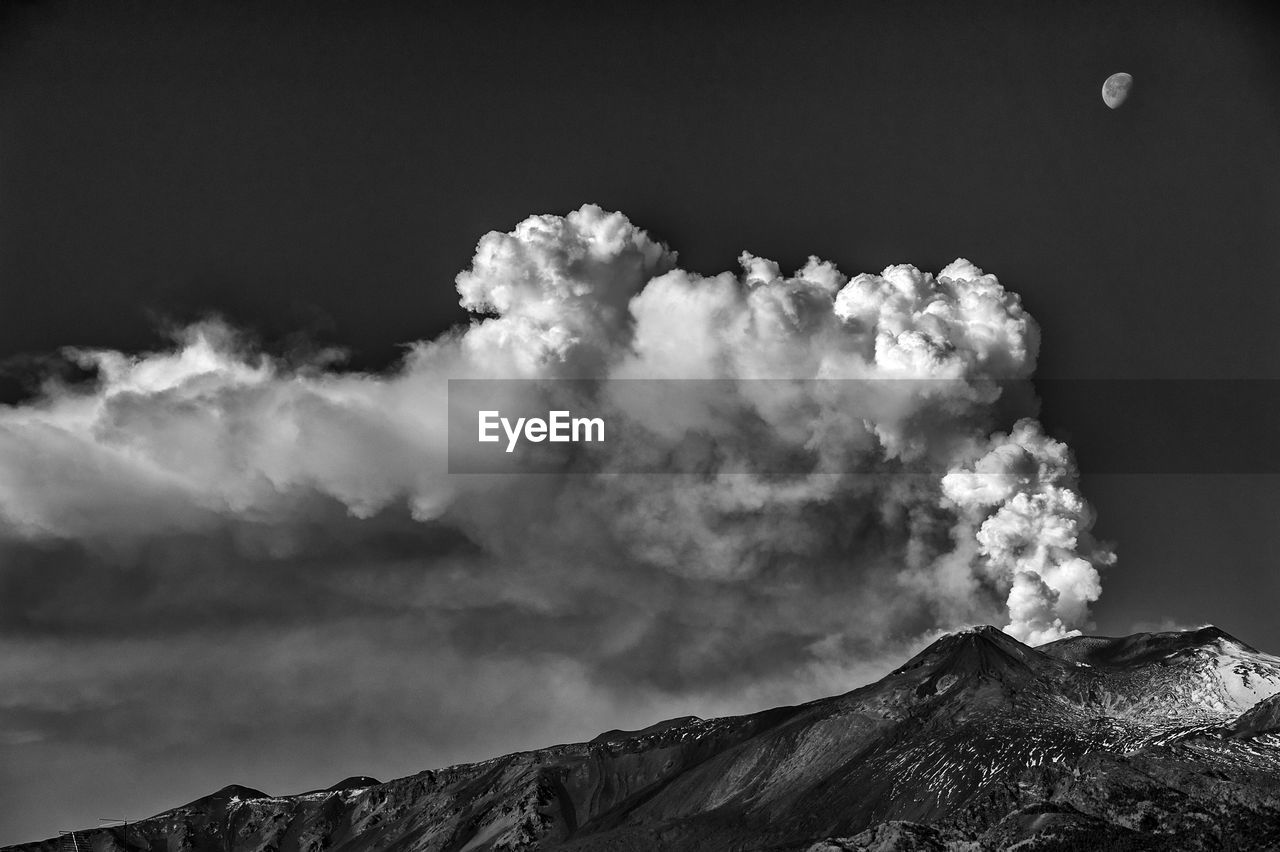 Smoke emitting from volcanic mountain against sky