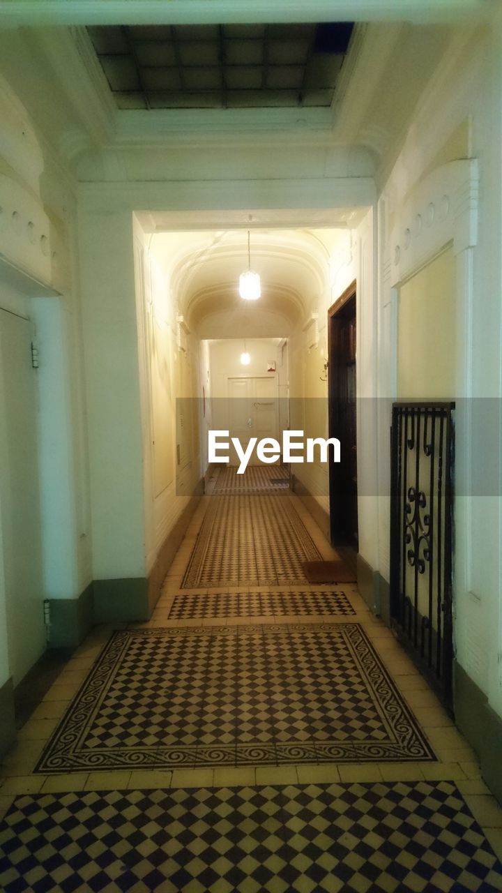 EMPTY CORRIDOR OF ILLUMINATED BUILDING