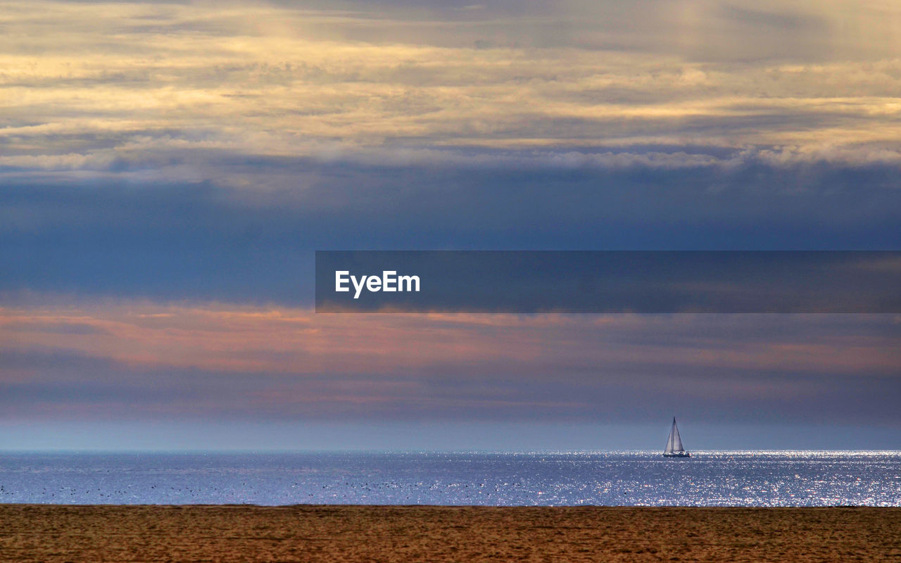 View of calm sea against cloudy sky