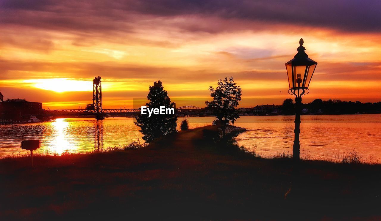 SILHOUETTE TREES ON LAKE AGAINST SKY DURING SUNSET