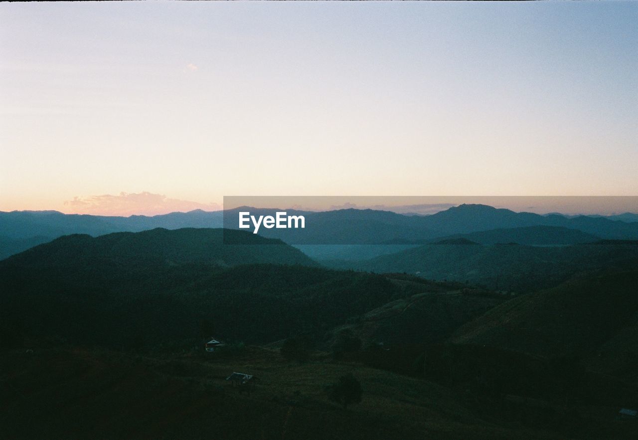 SCENIC VIEW OF MOUNTAINS AGAINST CLEAR SKY AT DUSK