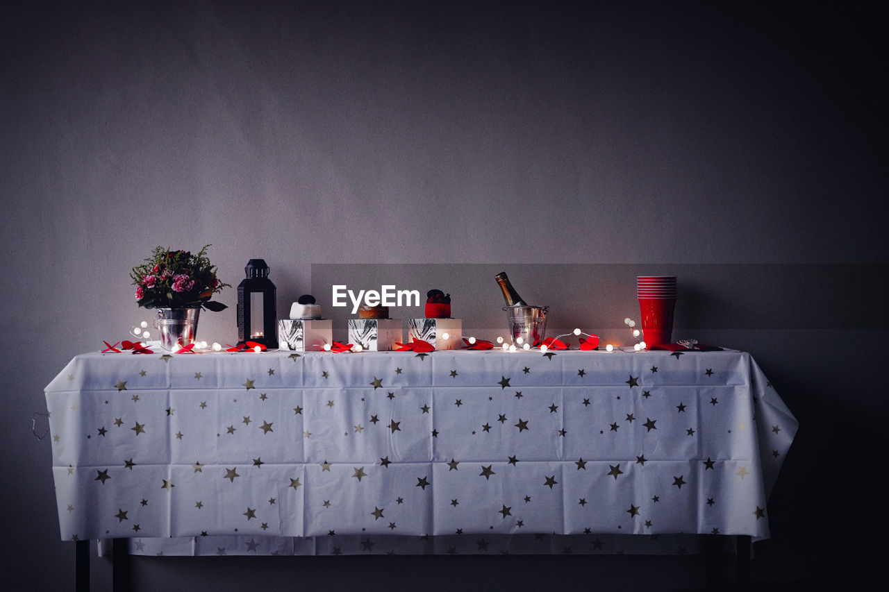 Close-up of decorations on table against wall