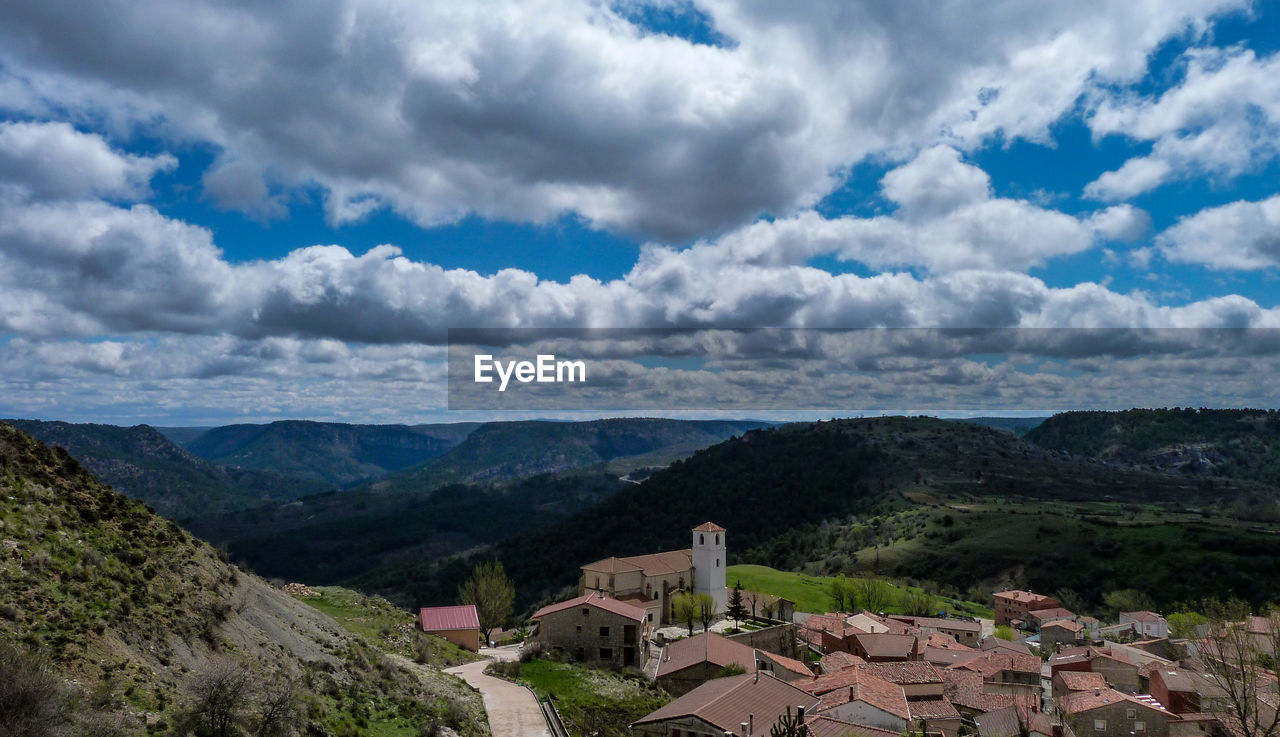 HIGH ANGLE VIEW OF TOWNSCAPE BY MOUNTAINS