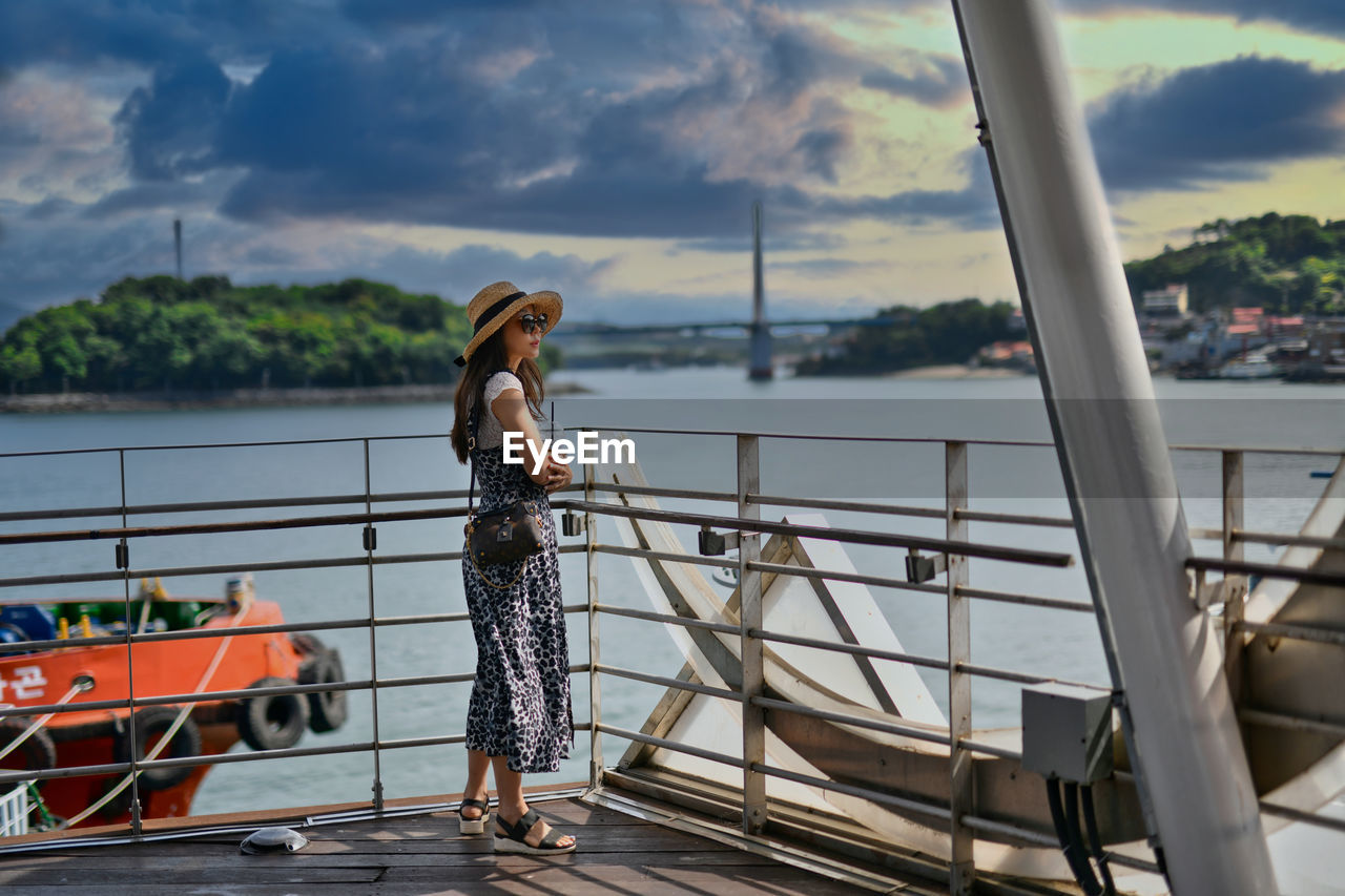 Rear view of woman standing in boat