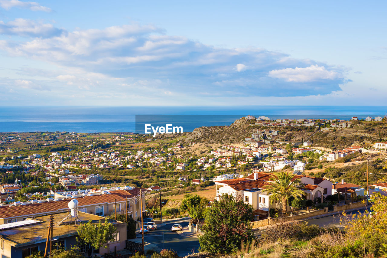 HIGH ANGLE SHOT OF TOWNSCAPE AGAINST SEA