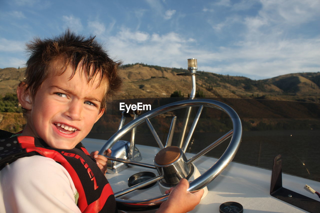 Low angle view of person holding wheel against sky