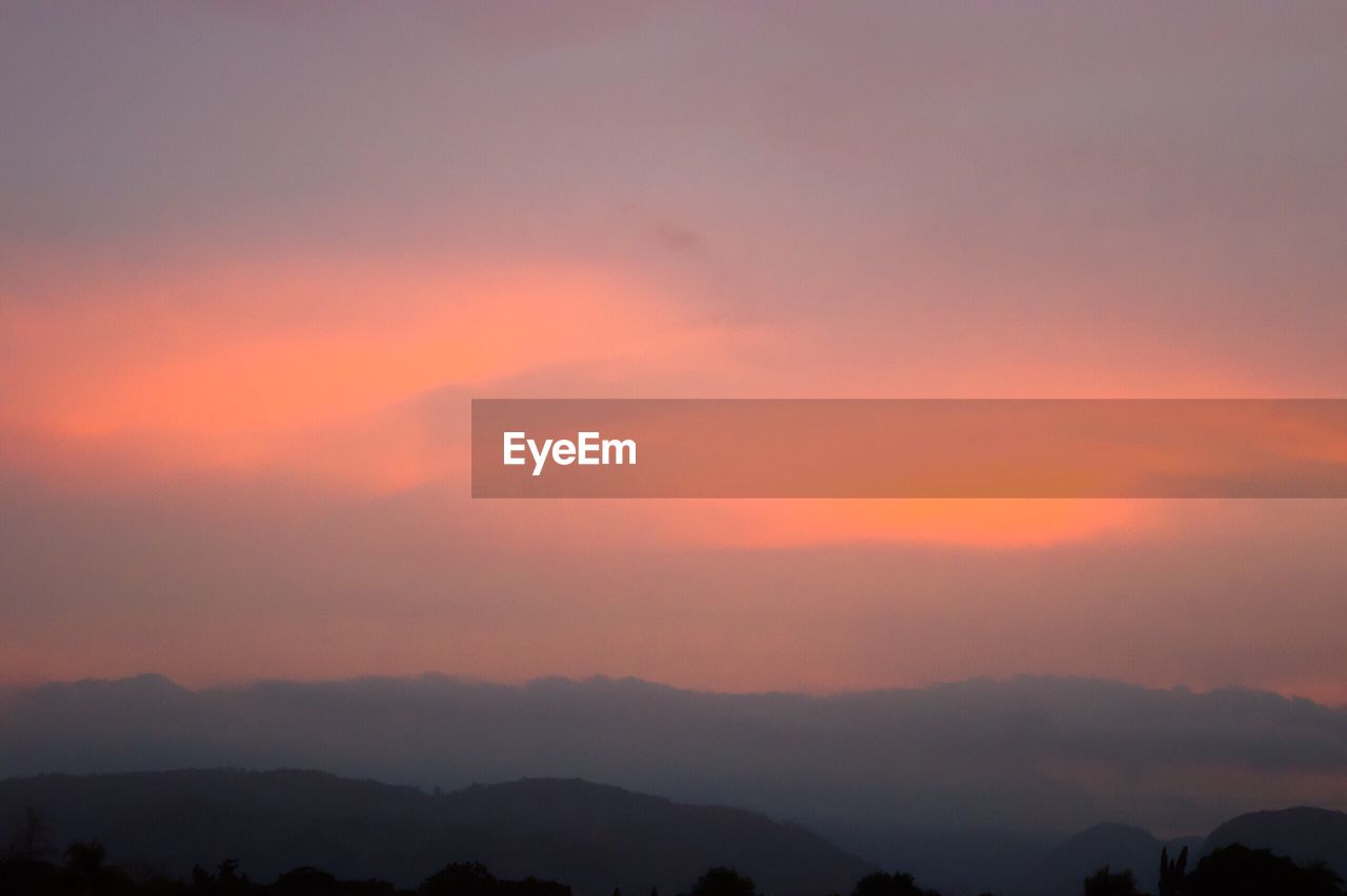 SCENIC VIEW OF MOUNTAINS AT SUNSET