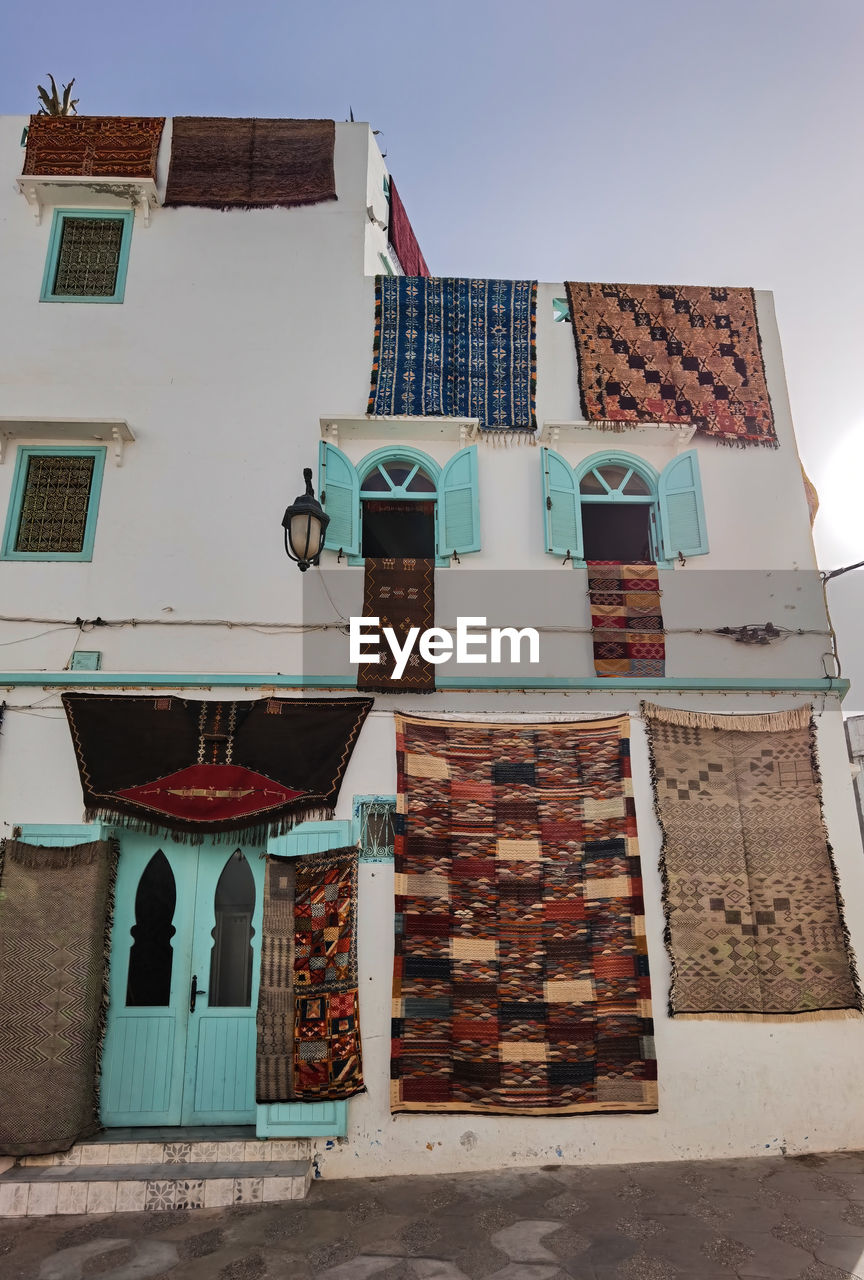 Handmade moroccan carpets hanging on the building of a carpet store in asilah