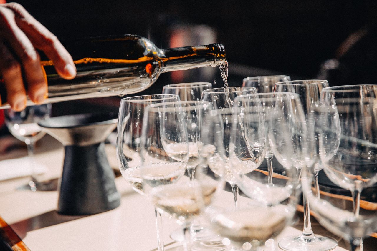 cropped hand of woman holding wineglass on table