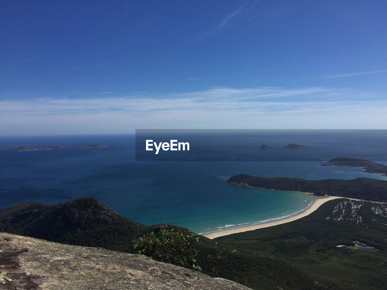 Scenic view of sea and mountains against blue sky