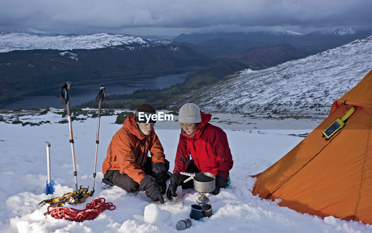 Couple reading map on the side of helvellyn mountain