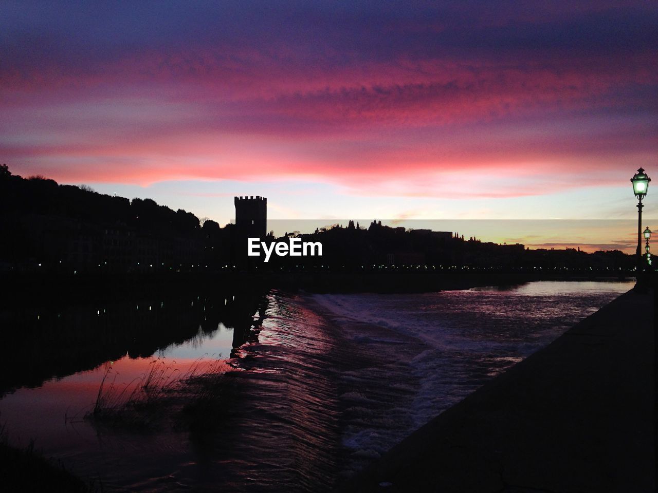 SUNSET OVER RIVER WITH BUILDINGS IN BACKGROUND