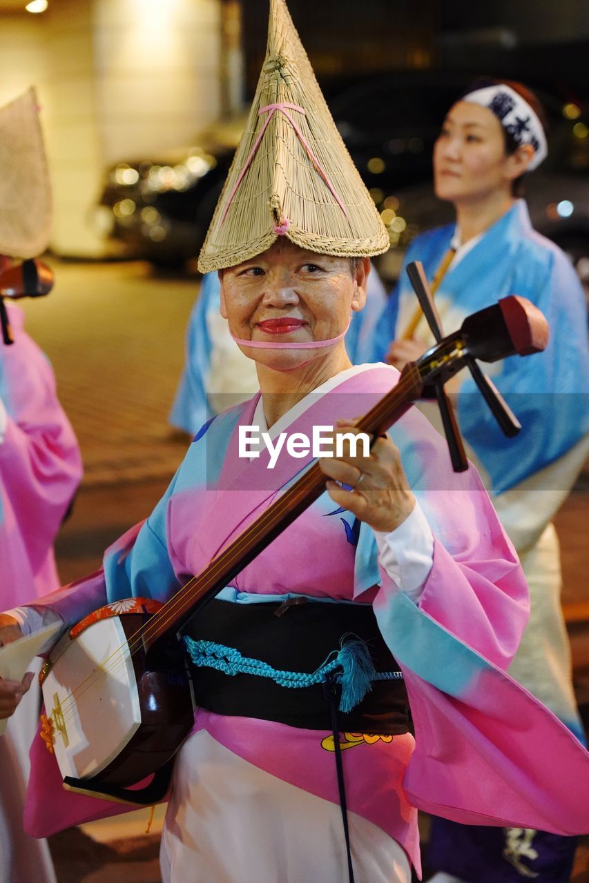 PEOPLE IN TRADITIONAL CLOTHING STANDING AT MUSIC