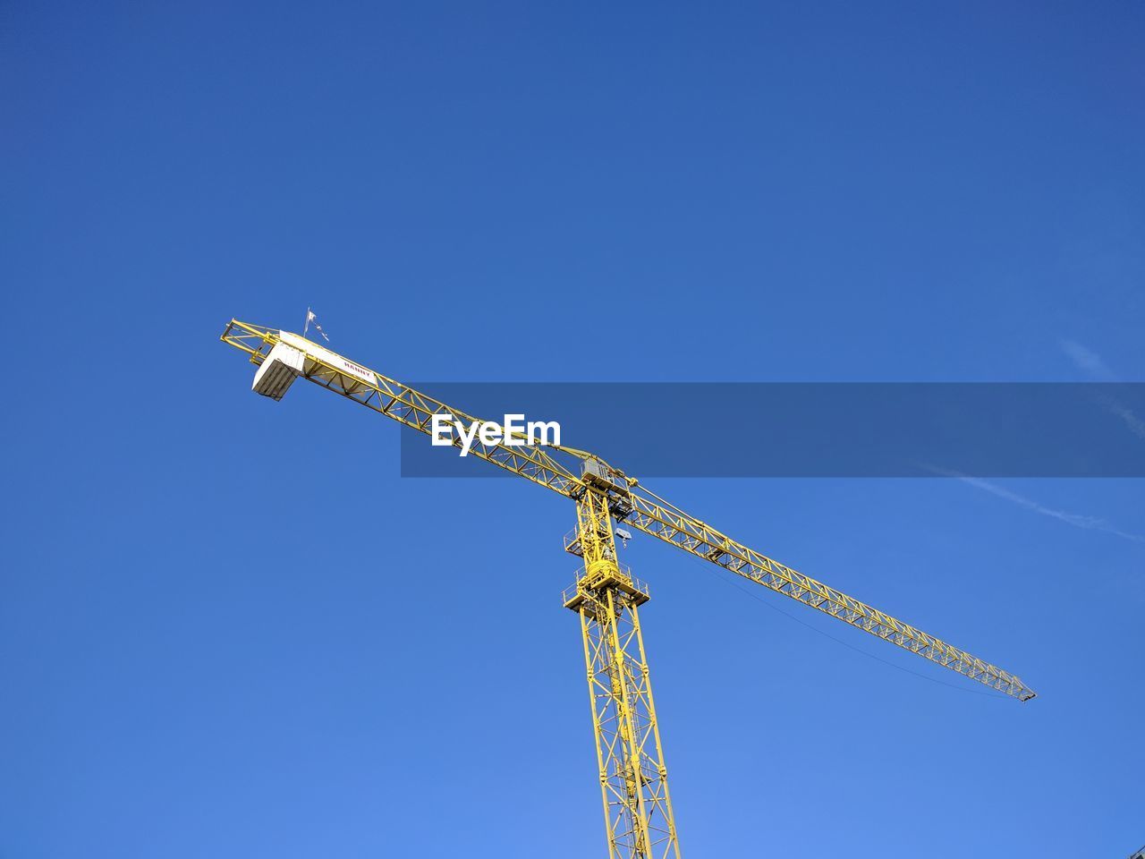 LOW ANGLE VIEW OF CRANE AGAINST BLUE SKY