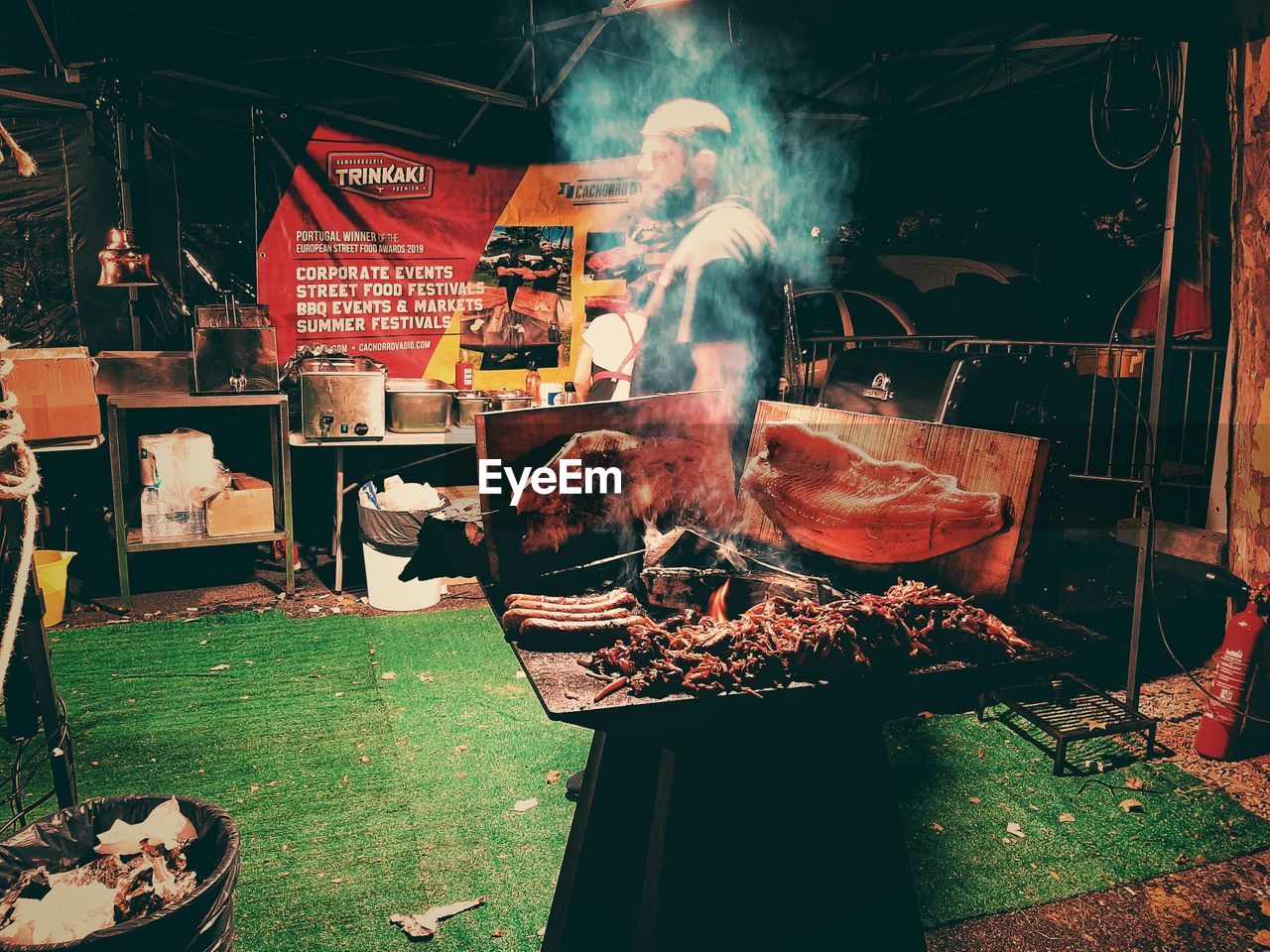 HIGH ANGLE VIEW OF MAN AND BARBECUE GRILL