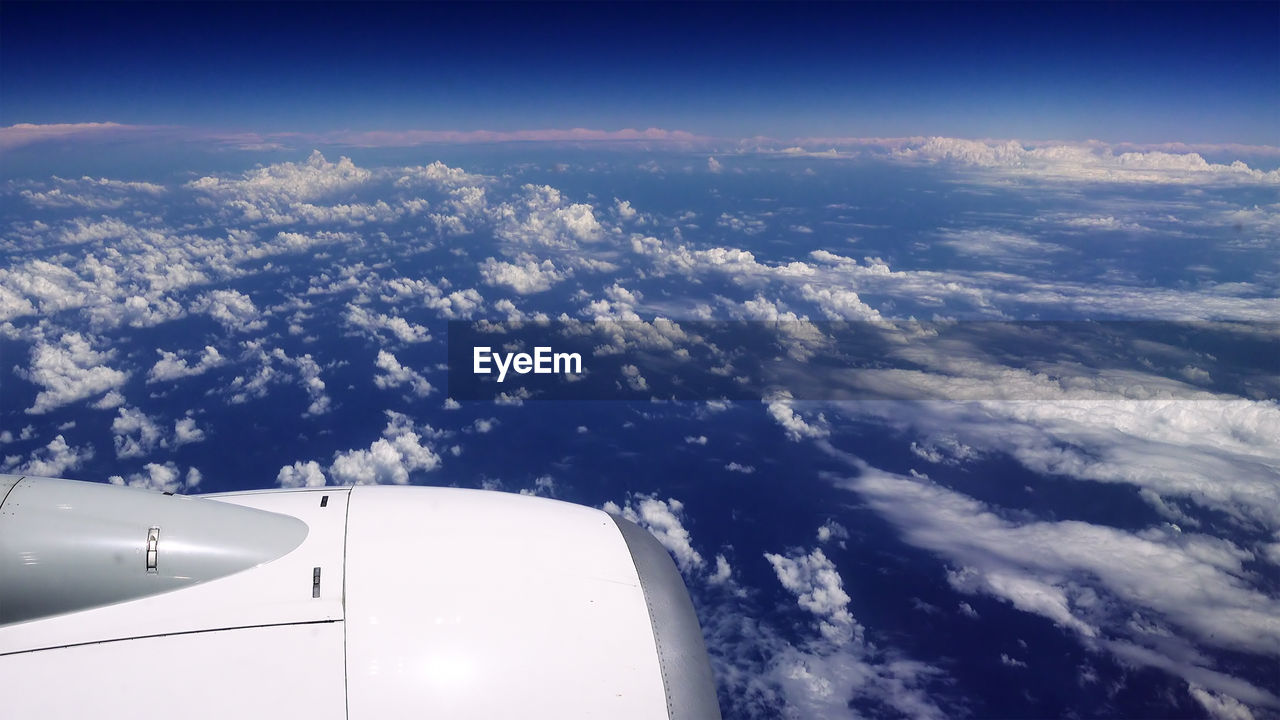 AERIAL VIEW OF AIRCRAFT WING AGAINST SKY