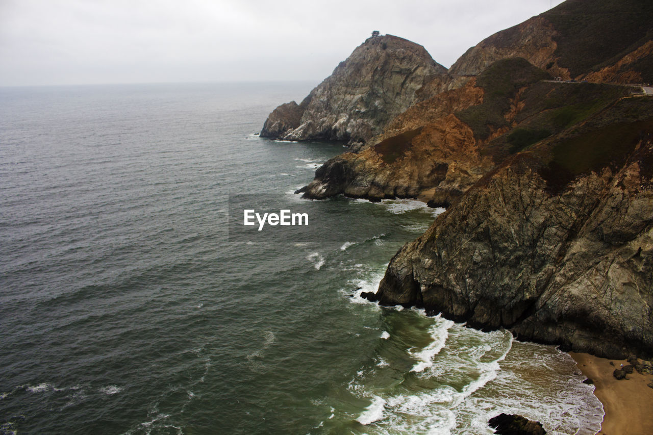 Rock formation in sea against sky