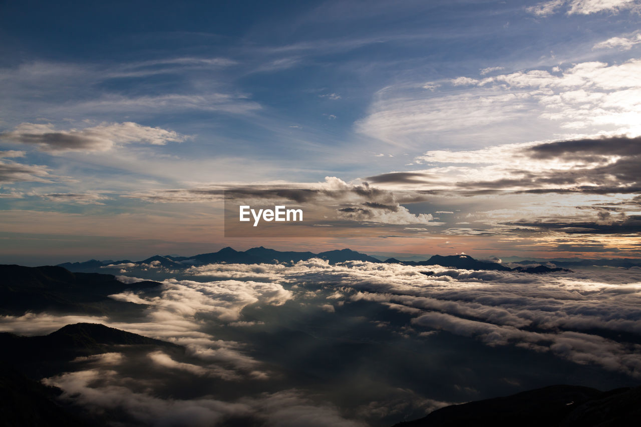 Aerial view of clouds over mountains during sunset