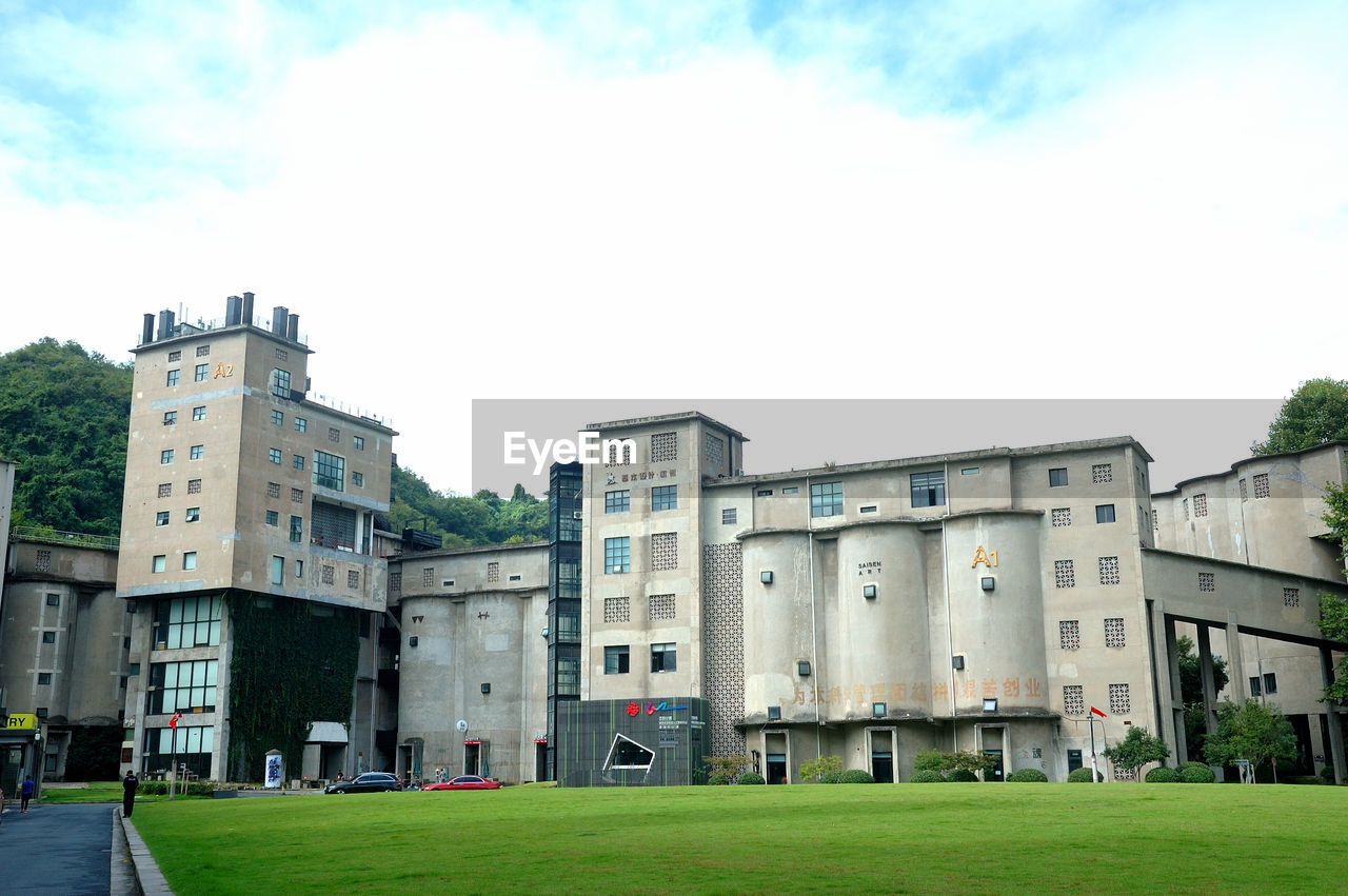 BUILDINGS AGAINST SKY WITH LAWN IN FOREGROUND