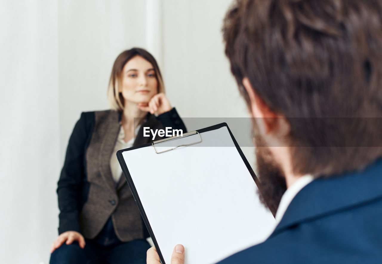 businesswoman using digital tablet while standing against white background