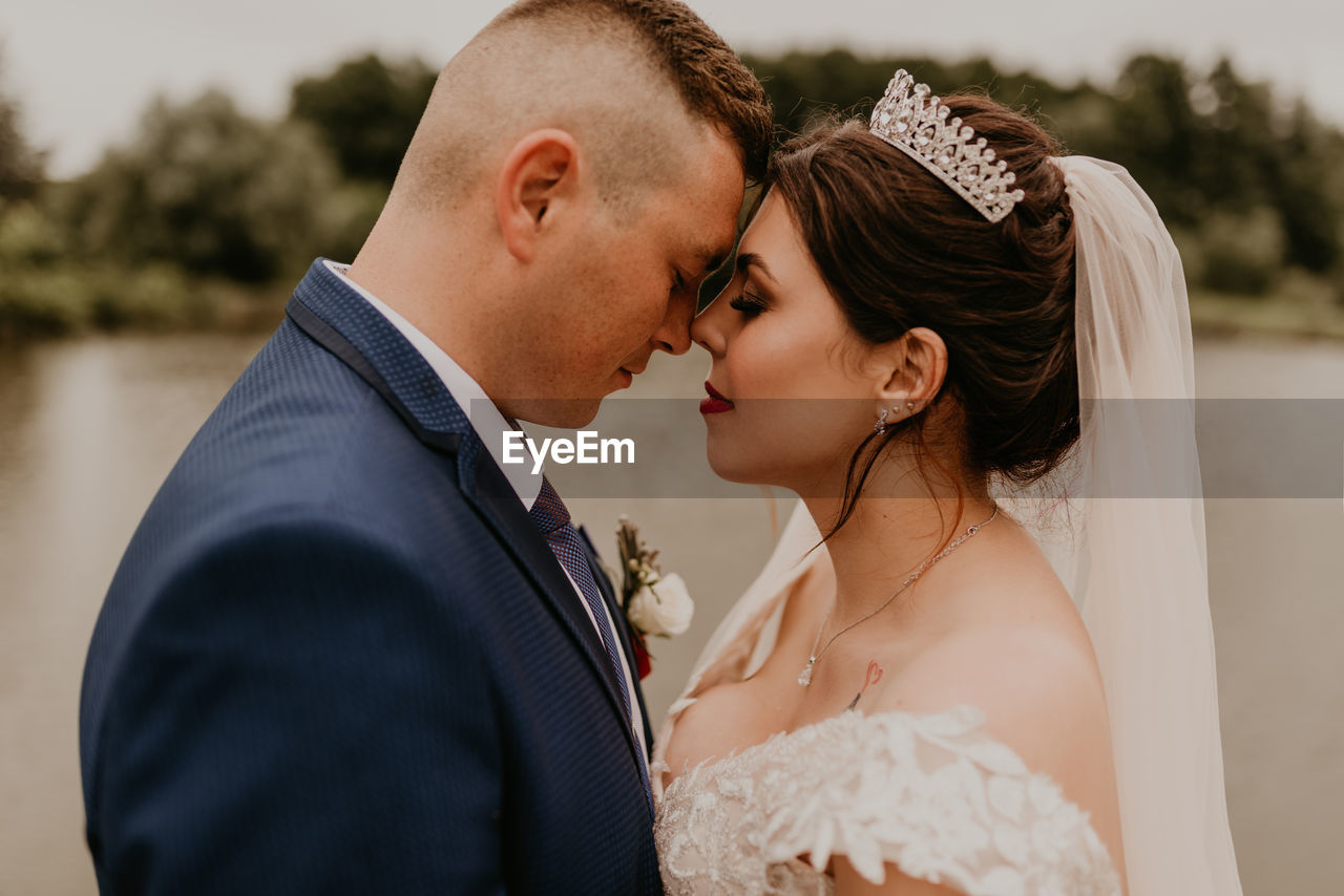 side view of bride and bridegroom holding bouquet