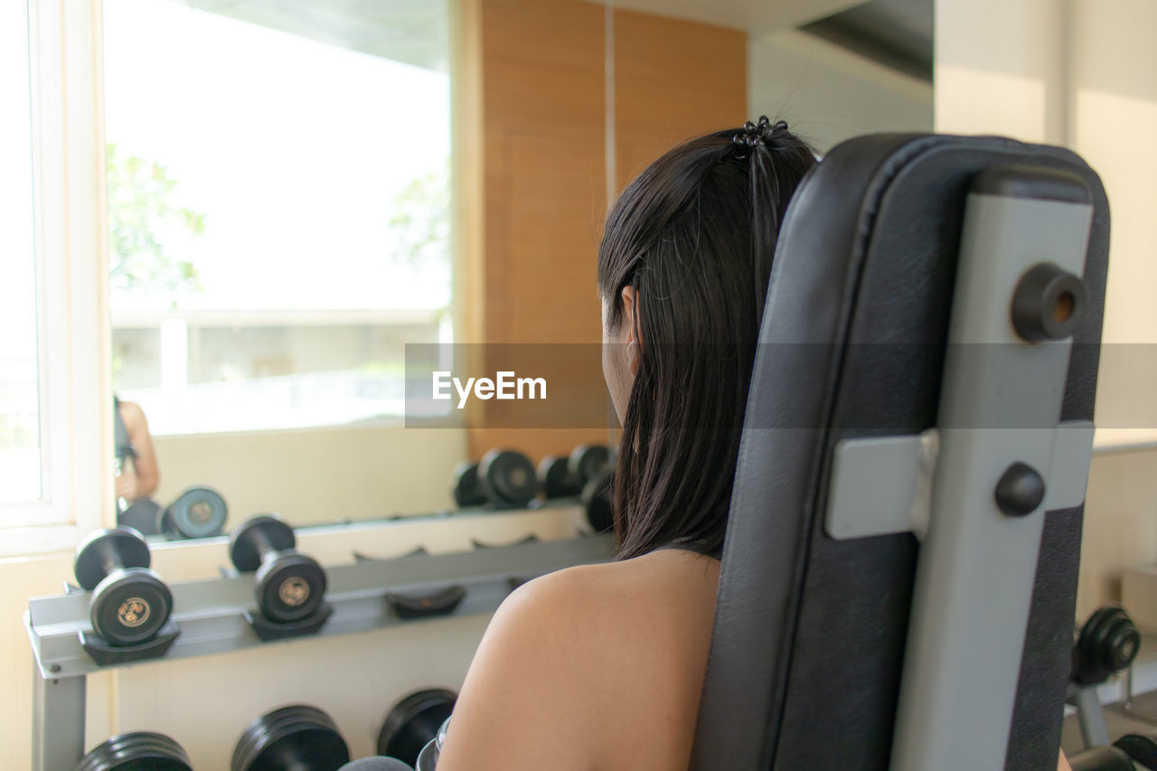 Rear view of woman exercising at gym