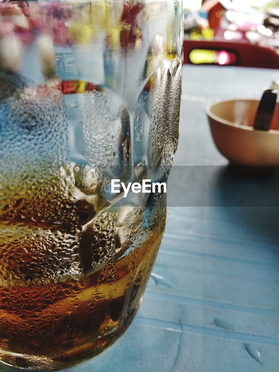 CLOSE-UP OF DRINK ON GLASS TABLE