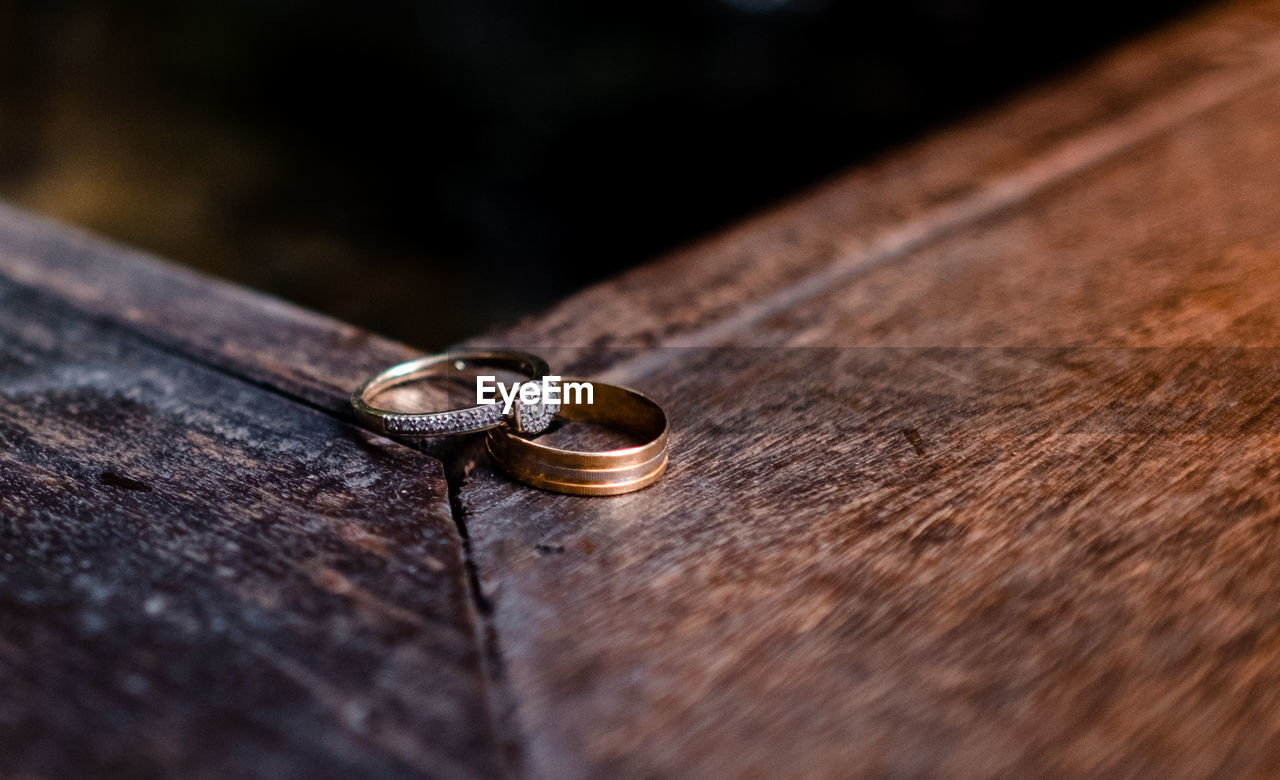 Close-up of wedding rings on wood