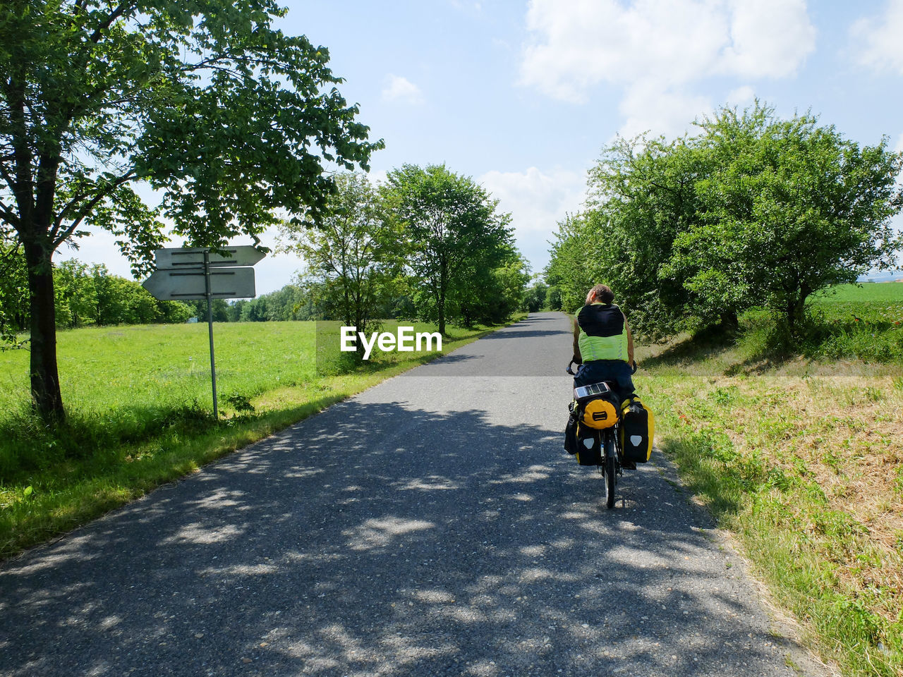 REAR VIEW OF WOMAN RIDING MOTORCYCLE