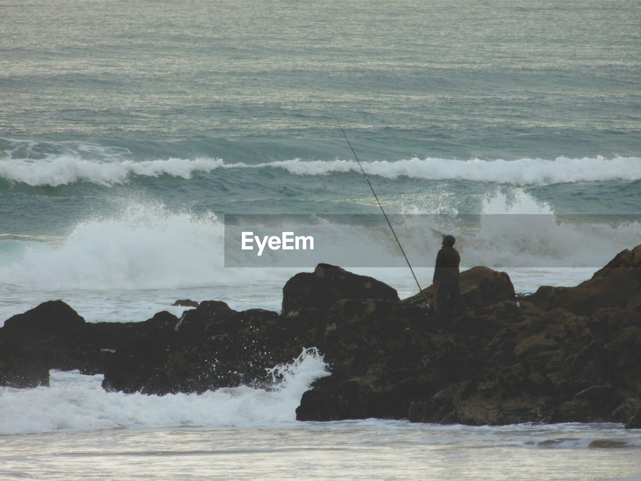 Man fishing at rocky shore