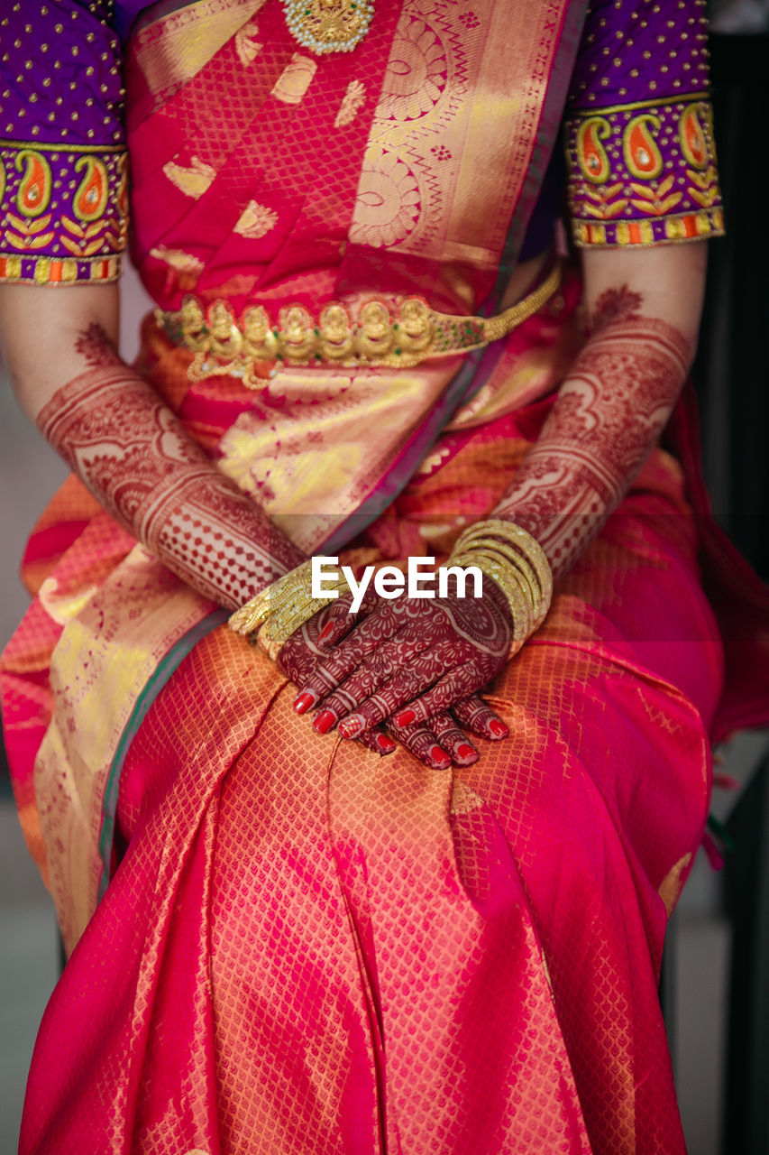 Midsection of bride wearing sari and jewelry