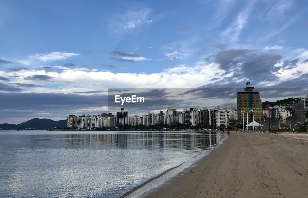 SCENIC VIEW OF SEA BY BUILDINGS AGAINST SKY