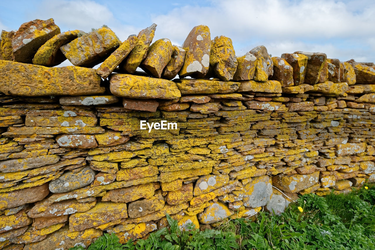 STACK OF OLD STONE WALL AGAINST SKY