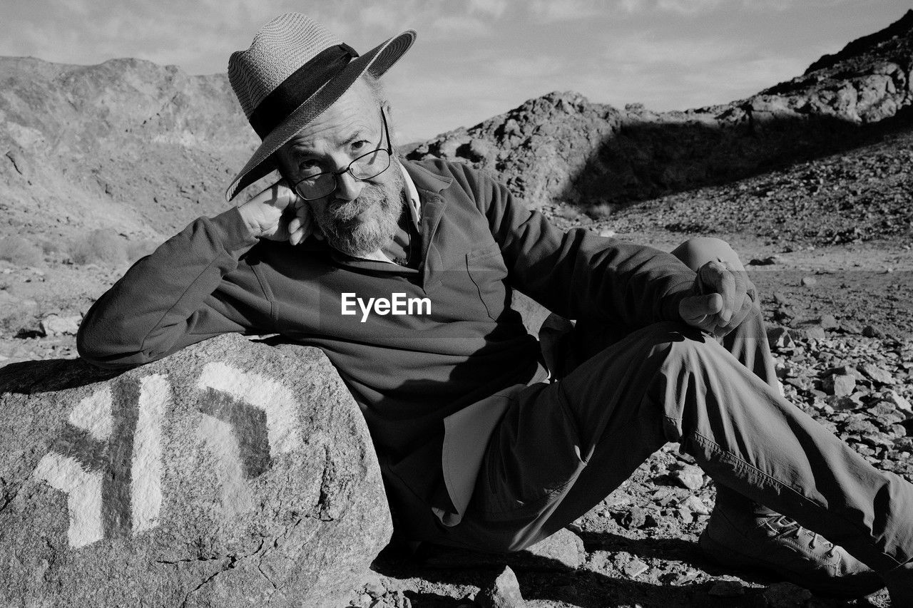 portrait of man sitting on rock