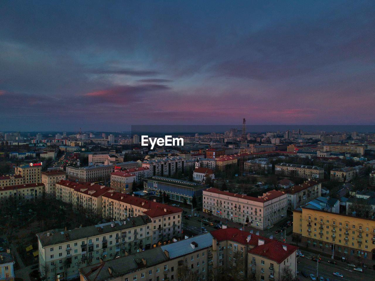 High angle view of city buildings against cloudy sky