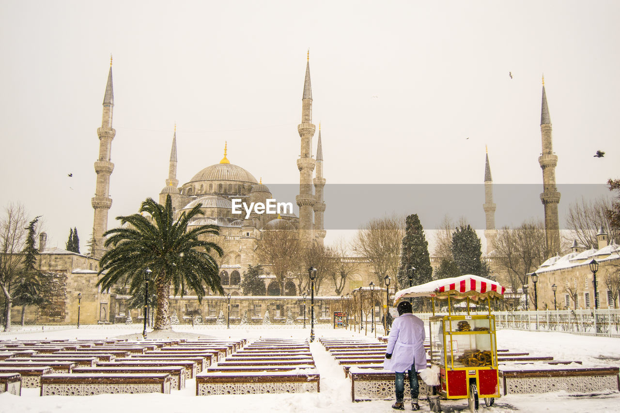 Low angle view of mosque against clear sky during winter