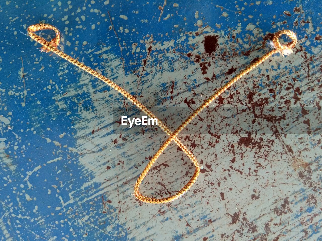 DIRECTLY ABOVE SHOT OF RUSTY METAL AGAINST BLUE SKY