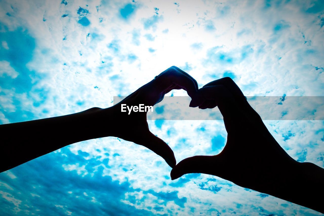 CLOSE-UP OF HEART SHAPE AGAINST CLOUDY SKY