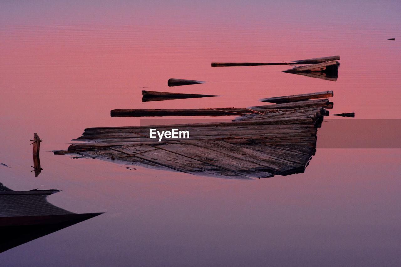 Boats moored at beach against sky during sunset