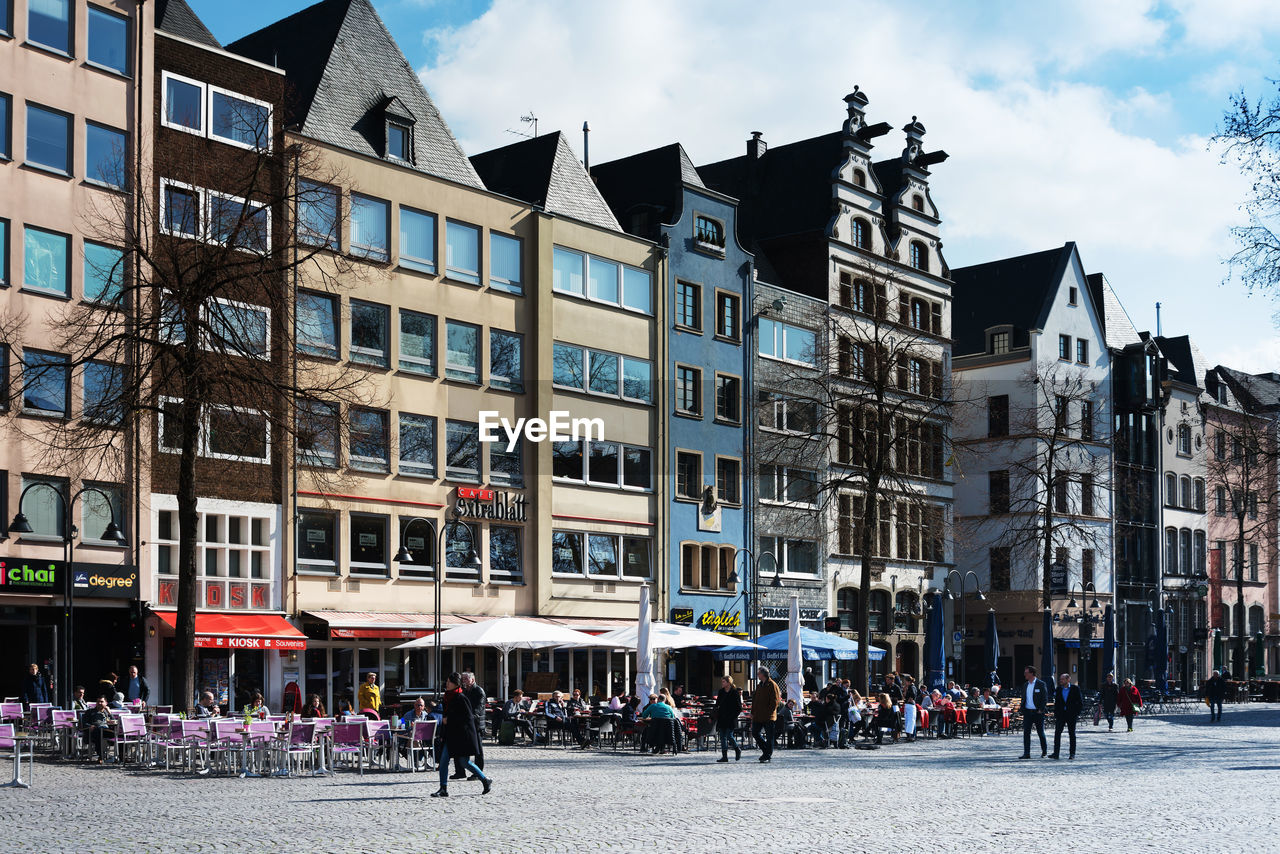 People on street in city by buildings