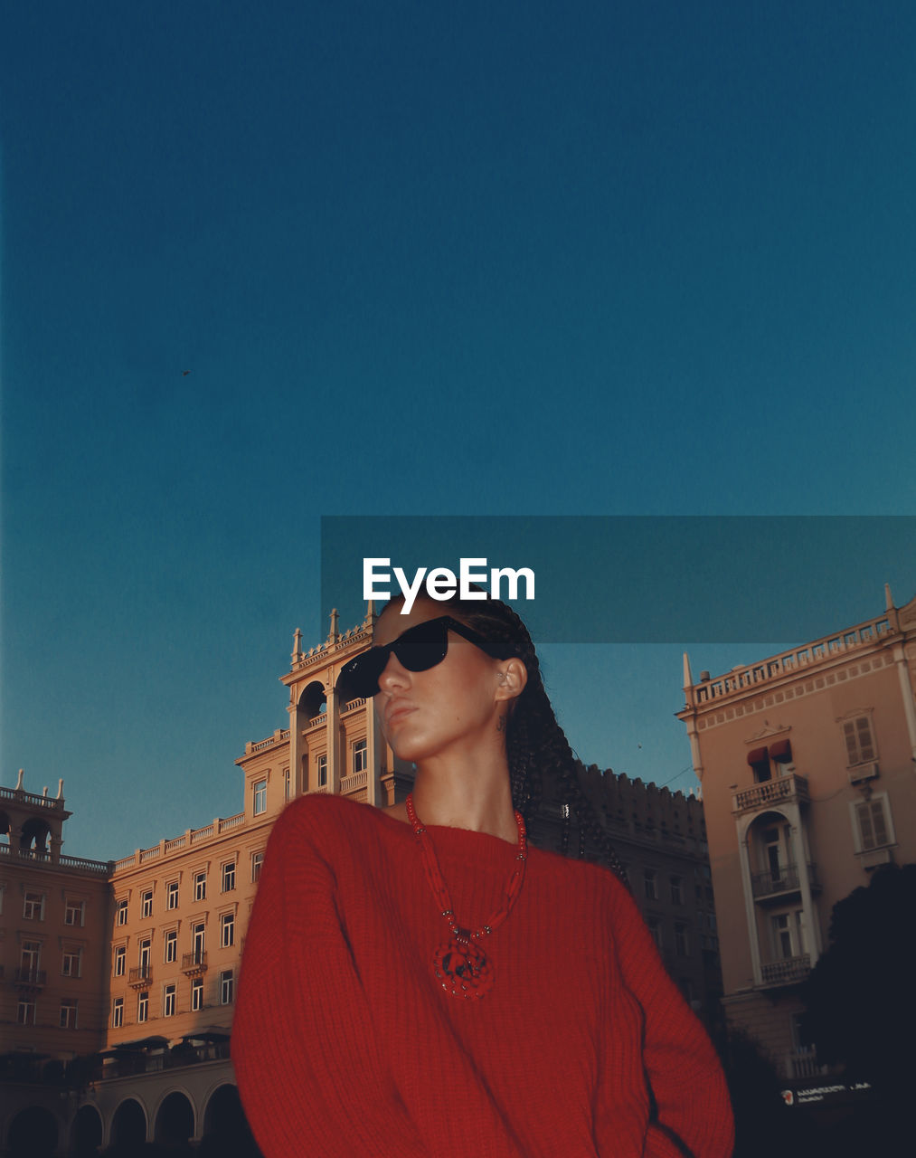 Young woman standing against clear blue sky