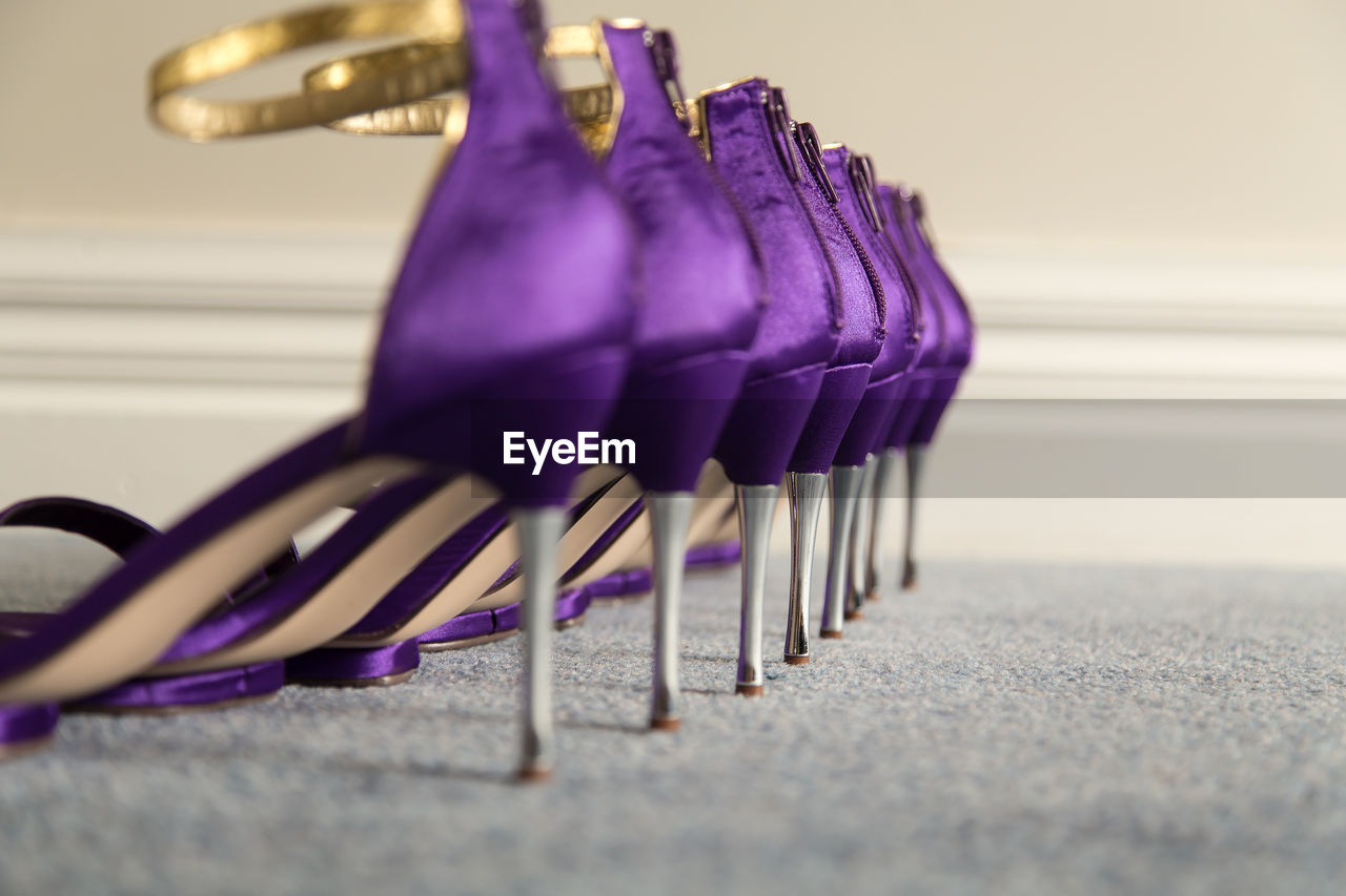 Row of purple high heels on carpet