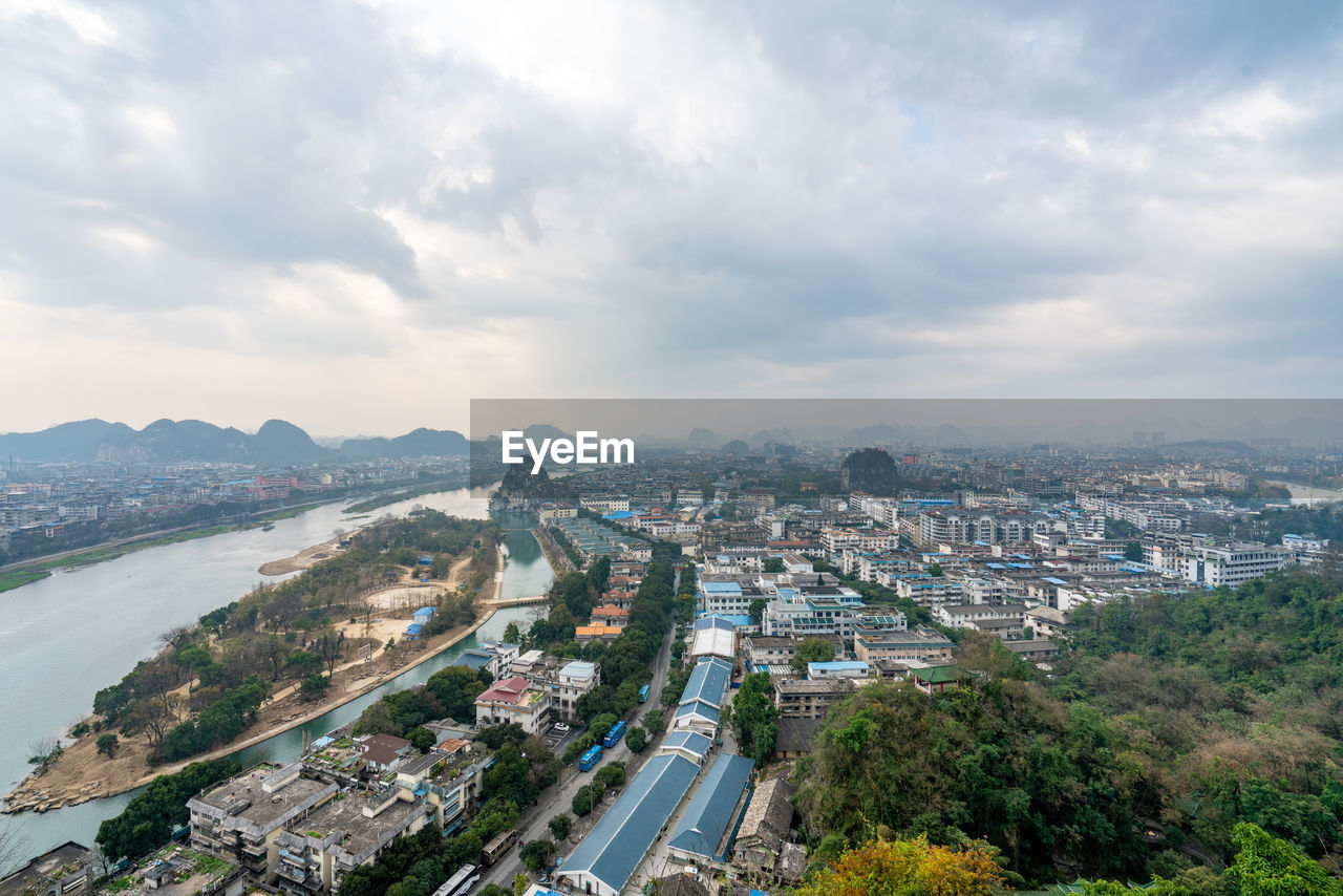 HIGH ANGLE VIEW OF ROAD BY BUILDINGS IN CITY