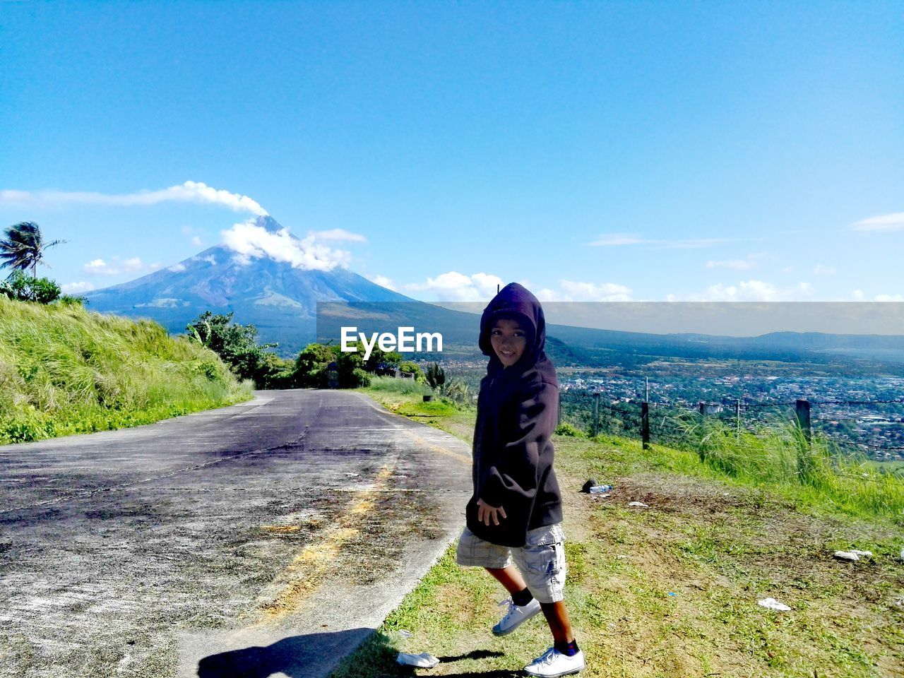 Portrait of boy walking on field against sky