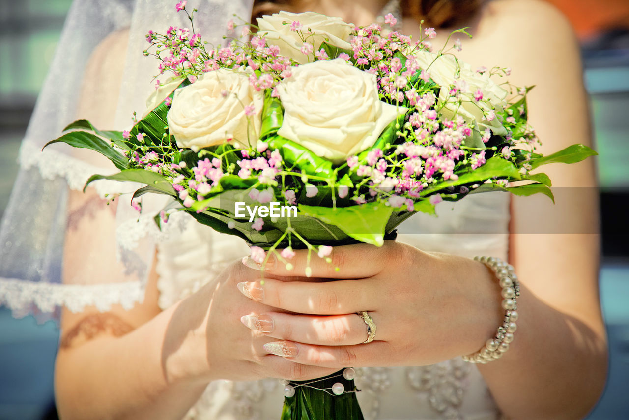 Close-up of bride holding rose bouquet