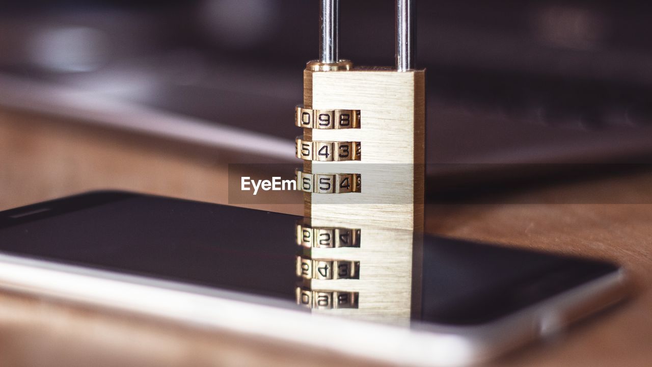 Close-up of padlock and smart phone