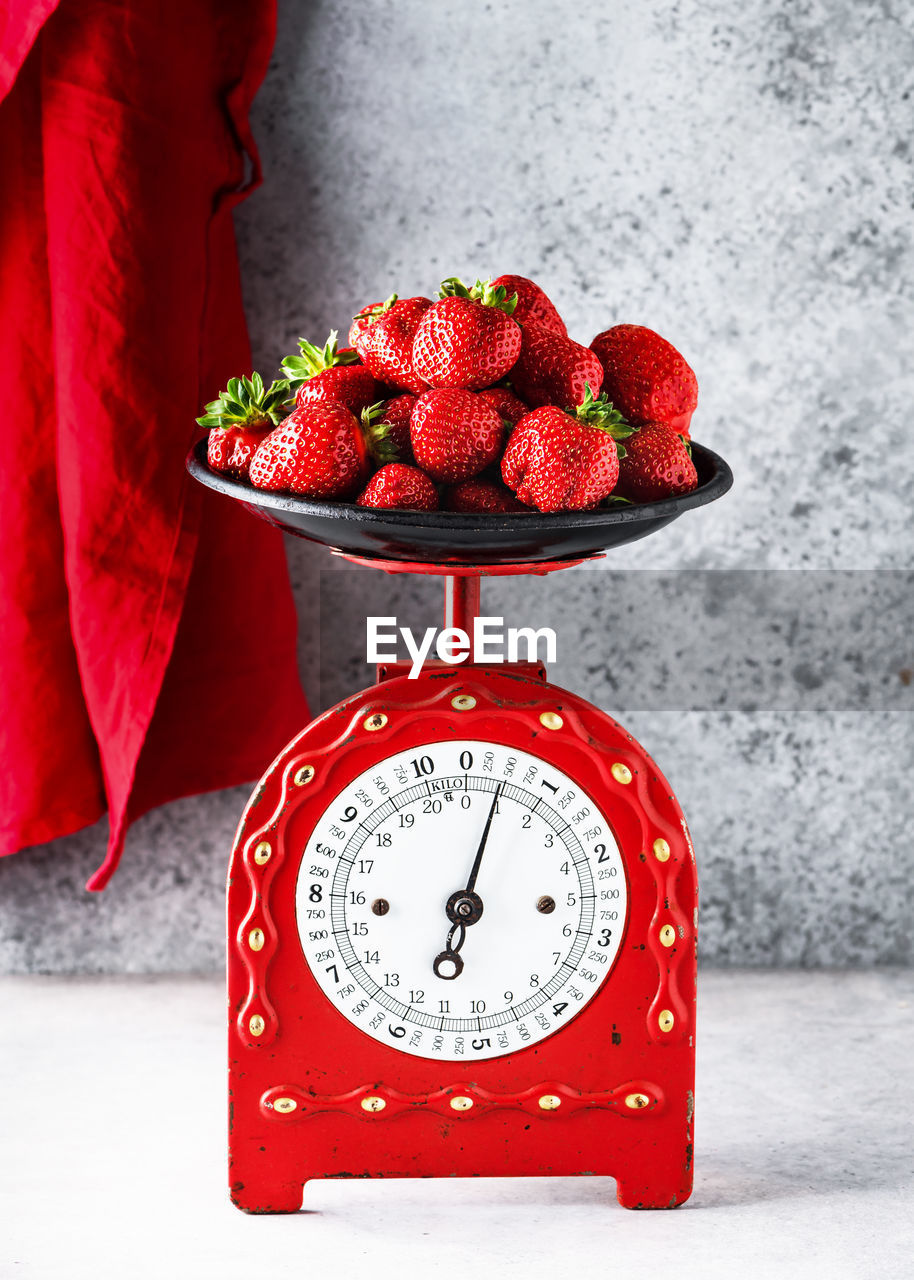 Retro red scales with a handful of fresh ripe organic strawberries. healthy vegan food concept. 