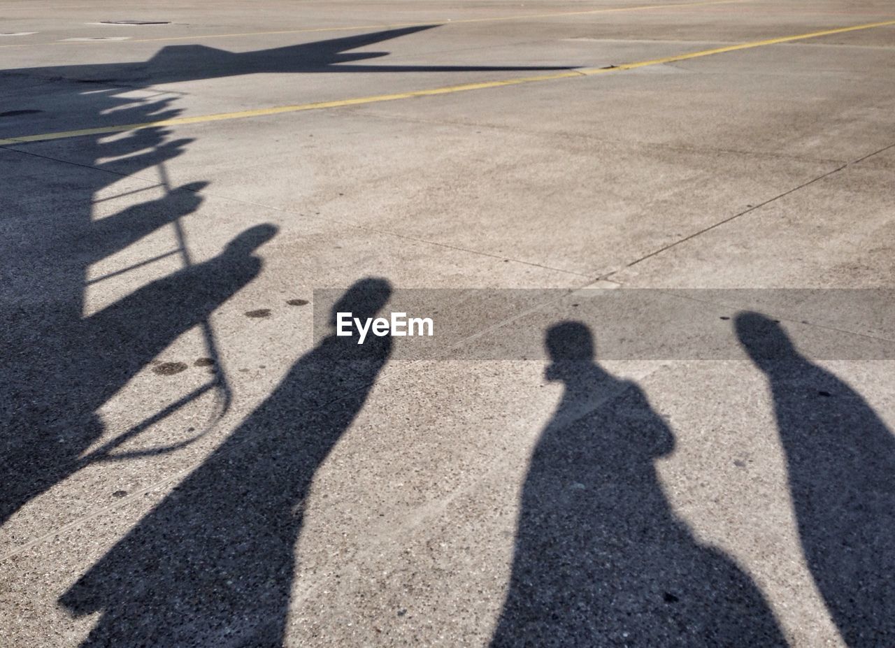 Shadow of people boarding airplane