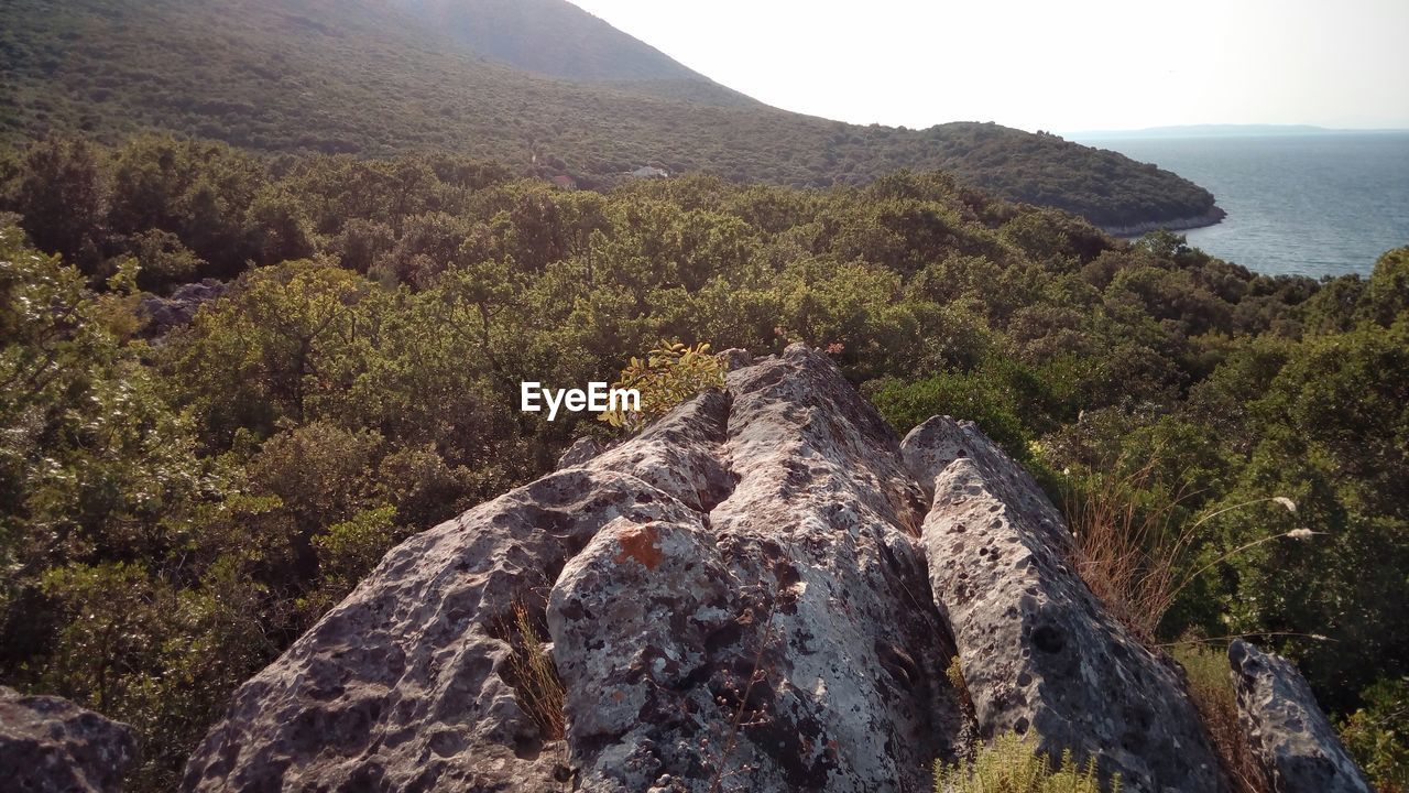 Scenic view of mountain by sea against sky